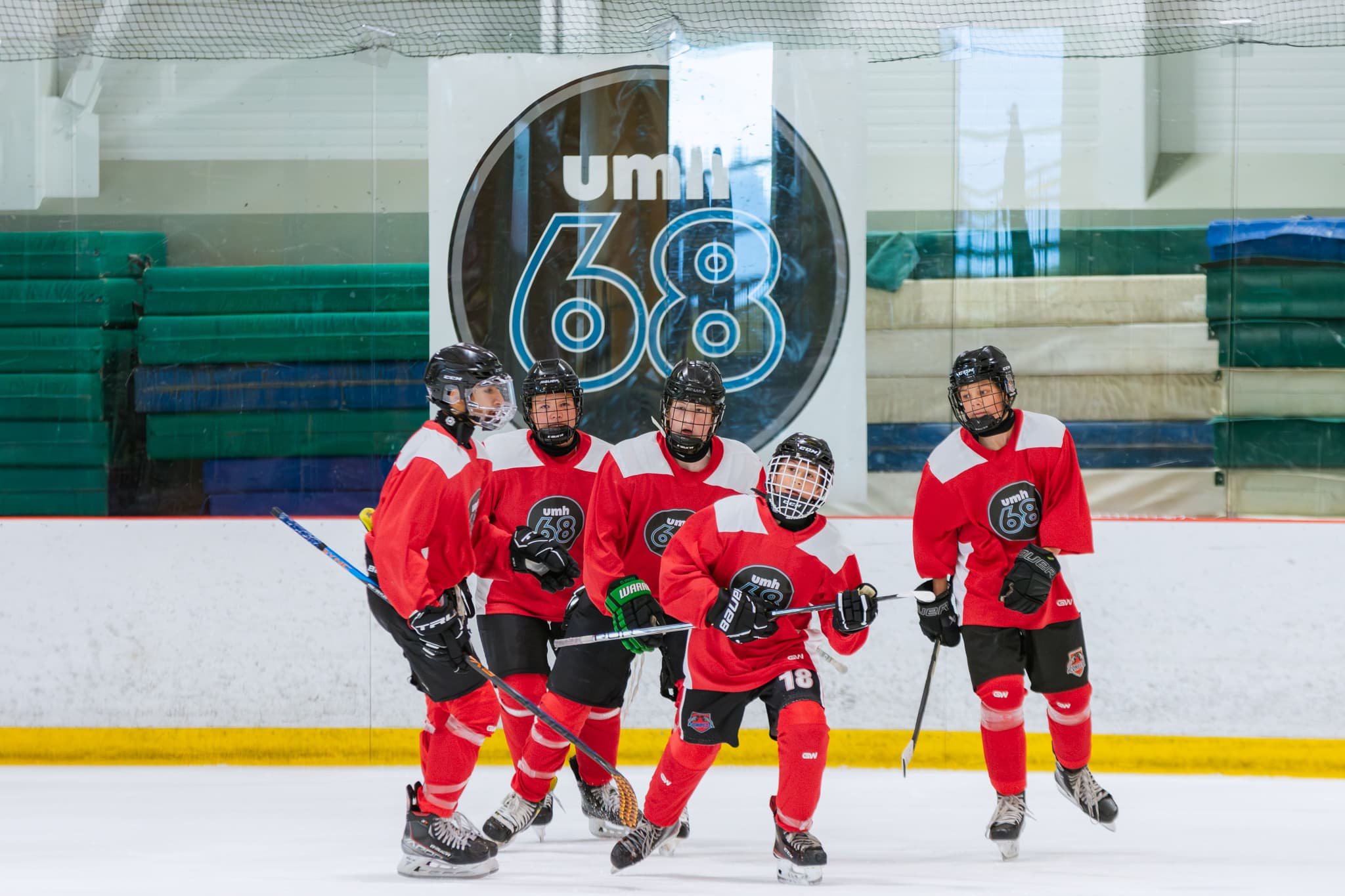UMH-68 players in red jerseys gathering on the ice